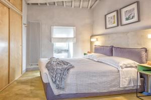 Schlafzimmer mit einem Bett und einem Fenster in der Unterkunft Casa Colonia - Together in Tuscany in Cortona