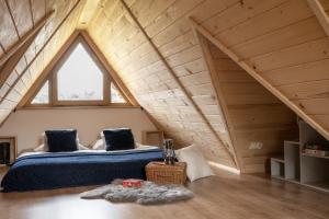 ein Schlafzimmer mit einem Bett im Dachgeschoss in der Unterkunft Domek Zakopane Tatrzański Kącik APARTZAKOP in Zakopane