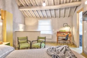 1 Schlafzimmer mit 2 Stühlen und einem Schreibtisch in der Unterkunft Casa Colonia - Together in Tuscany in Cortona