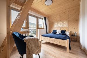 1 dormitorio con 1 cama azul en una casa de madera en Domek Zakopane Tatrzański Kącik APARTZAKOP, en Zakopane
