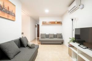 a living room with a couch and a tv at Apartment next to Europa Fira and 20' from Barcelona city center in Hospitalet de Llobregat