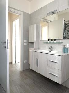 cocina blanca con lavabo y espejo en Casa Toè de Luxe, en Conegliano