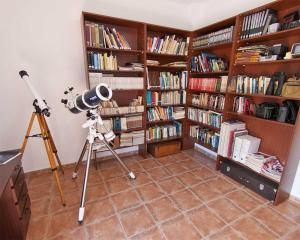 uma câmara e um tripé numa sala com livros em Villa Asunción A em Breña Baja