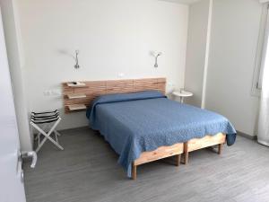 1 dormitorio con cama de madera y manta azul en Casa Toè de Luxe, en Conegliano