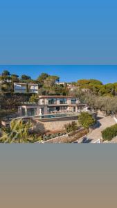 una casa sulla spiaggia con l'oceano sullo sfondo di Villa Paulina MOUGINS a Mougins
