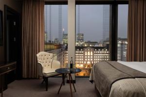 Montcalm Royal London House, London City في لندن: غرفة فندقية بسرير وطاولة ونافذة