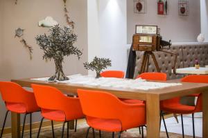 a table with orange chairs and a camera at Sweet Home Hotel in Athens