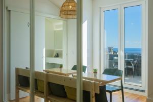 a dining room with a table and a view of the ocean at Sky PDL in Ponta Delgada