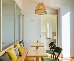 a dining room with a wooden table and yellow pillows at Sky PDL in Ponta Delgada
