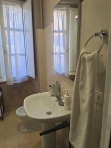 bagno con lavandino bianco e specchio di Candia41 a Roma