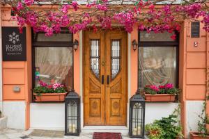 an orange house with a wooden door and flowers at Sweet Home Hotel in Athens