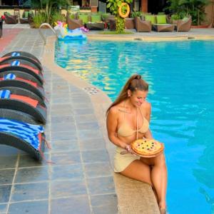 a woman sitting in a swimming pool holding a frisbee at Adamo The Bellus Calangute in Calangute