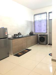 a kitchen with a stove and a microwave at D' HOME MERIDIAN in Kluang