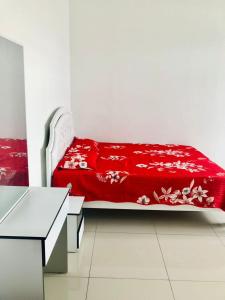 a bed with a red blanket on it in a room at D' HOME MERIDIAN in Kluang