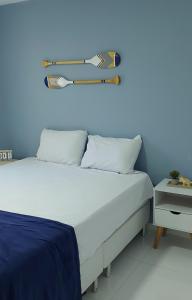 um quarto com uma cama com uma prancha de surf na parede em Caribean's house em Arraial do Cabo