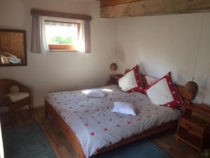 ein Schlafzimmer mit einem Bett mit roten und weißen Kissen in der Unterkunft Ferienhaus Uphaus in Scharpitz in Güstrowerhöfen