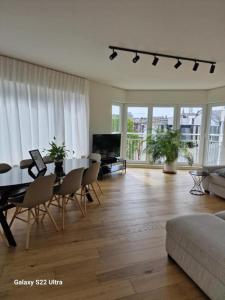 sala de estar amplia con mesa y sillas en Luxury Renovated 3 Rooms Apartment en Ostende