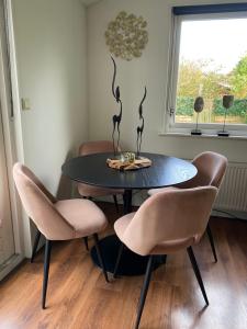 mesa de comedor con 2 sillas y mesa en Tiny house Schoorl Bergen NH, en Warmenhuizen