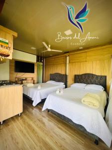 una camera d'albergo con due letti e una televisione di EcoHotel Brisas del Amani a Norcasia
