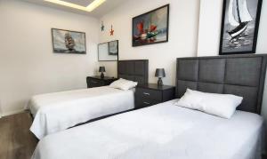 two beds in a bedroom with white sheets at Апартаменты Best Home 26 Cleopatra Legacy No 8 in Alanya