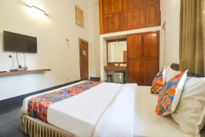 FabExpress Royal Baga Residency في أولد غوا: غرفة نوم بسرير كبير وتلفزيون