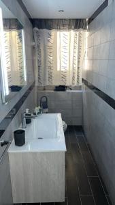 La salle de bains est pourvue d'un lavabo blanc et d'une baignoire. dans l'établissement the cousins' house, à Palerme