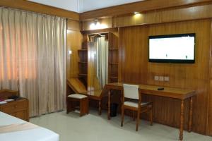 チッタゴンにあるHotel Saint Martin Ltd.の机と壁掛けテレビのある寝室 +13枚の写真