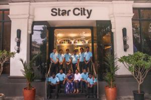 a group of people standing in front of a star city building at Hotel Star City in Chennai