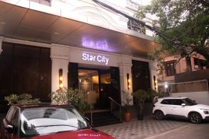 a car parked in front of a star city building at Hotel Star City in Chennai