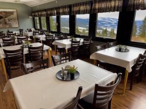 a dining room with tables and chairs and large windows at Øyer Fjellstugu in Øyer