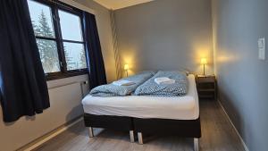 małe łóżko w pokoju z oknem w obiekcie Øyer Fjellstugu w mieście Øyer