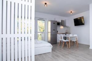 a room with a bed and a kitchen with a table at Large Studio - Balcony - Spa and Gym in Building - Free Parking in Sinaia