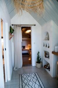 einen Flur mit einem Zimmer mit einem Bett und einem Vorhang in der Unterkunft Ma Maison d'Autre 