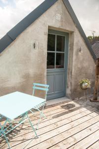 einen Tisch und Stühle auf einer Terrasse mit einem Haus in der Unterkunft Ma Maison d'Autre 