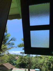 Una ventana en una casa con vistas al cielo en Morada Sunset Praia do Rosa, en Praia do Rosa