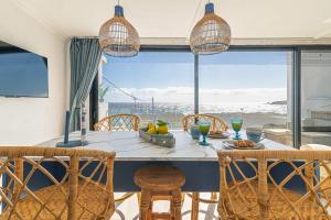 uma sala de jantar com mesa e cadeiras e uma grande janela em Brisa Marina em La Jaca