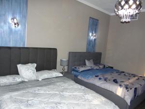 a bedroom with two beds and a chandelier at Huge Entire apartment for Couples ,families & Groups -up to 5 Guests- with free pool, steam & Sauna ,JVC,Dubai in Dubai
