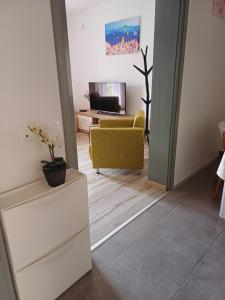 sala de estar con sillas amarillas y TV en Apartments Joy, en Cavtat