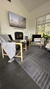 uma sala de estar com duas cadeiras e uma lareira em Mike's Kangaroo Valley em Kangaroo Valley