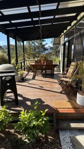 a wooden deck with a table and benches on it at Mike's Kangaroo Valley in Kangaroo Valley