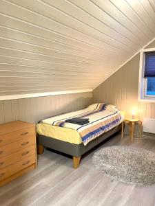 una camera con letto e pavimento in legno di Cozy house in an Arctic village 