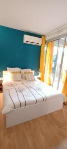 サン・シプリアンにあるAppartement cosy à deux pas du portの青い壁の客室の白いベッド1台
