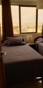 a bedroom with a bed and a large window at Hostal Ostello Amadeus in Arica