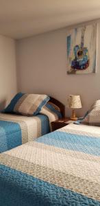 ein Schlafzimmer mit 2 Betten und einer Lampe auf einem Tisch in der Unterkunft Hostal Ostello Amadeus in Arica