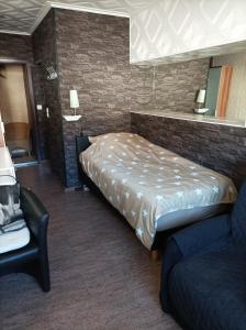 een slaapkamer met een bed, een stoel en een spiegel bij Fitness Pension in Sulingen