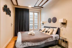 a bedroom with a large bed with a window at Urban Flat 73 - Luxury Parisian Flat near Les Halles Rivoli in Paris
