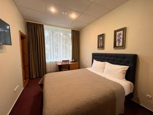 une chambre d'hôtel avec un lit et une fenêtre dans l'établissement Hotel - cafe Naujoji Akmenė, à Naujoji Akmenė