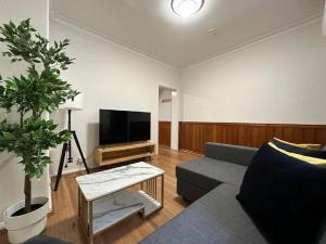 a living room with a couch and a tv at 2 Bedroom Darling Harbour - Pyrmont 2 E-Bikes Included in Sydney