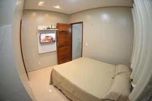 a small bedroom with a bed and a tv at Residencial Rosê - flats mobiliados in Ubajara