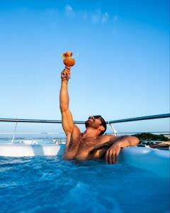 a man laying in a swimming pool on a boat at BELLAVISTA EXCLUSIVE B&B VISTA LAGO Piscina riscaldata e Jacuzzi in Desenzano del Garda